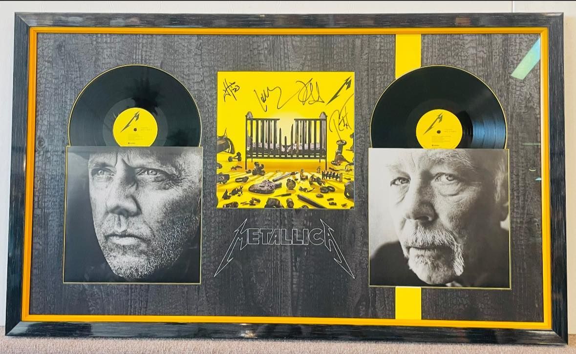 Framed Metallica album display: Vinyl records bookend album art and portraits of men, yellow accents.