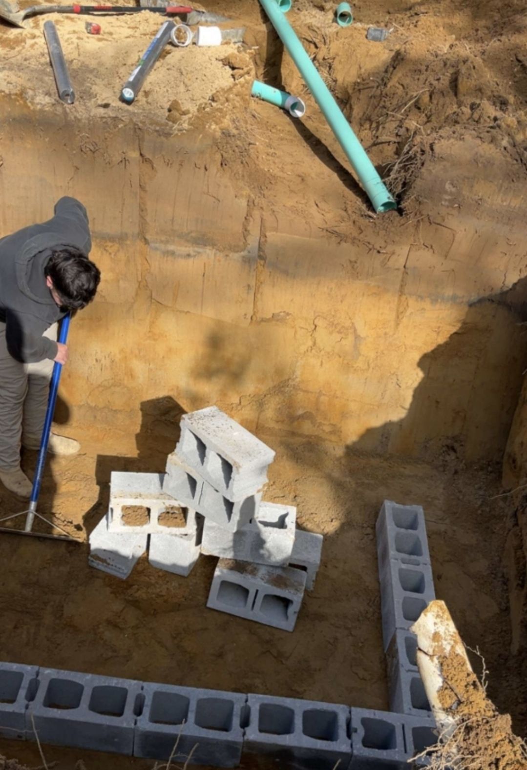 A man is digging in the dirt with a shovel