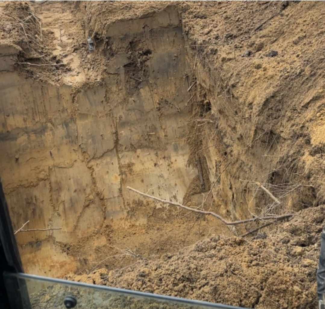 A man is digging in the dirt with a shovel.
