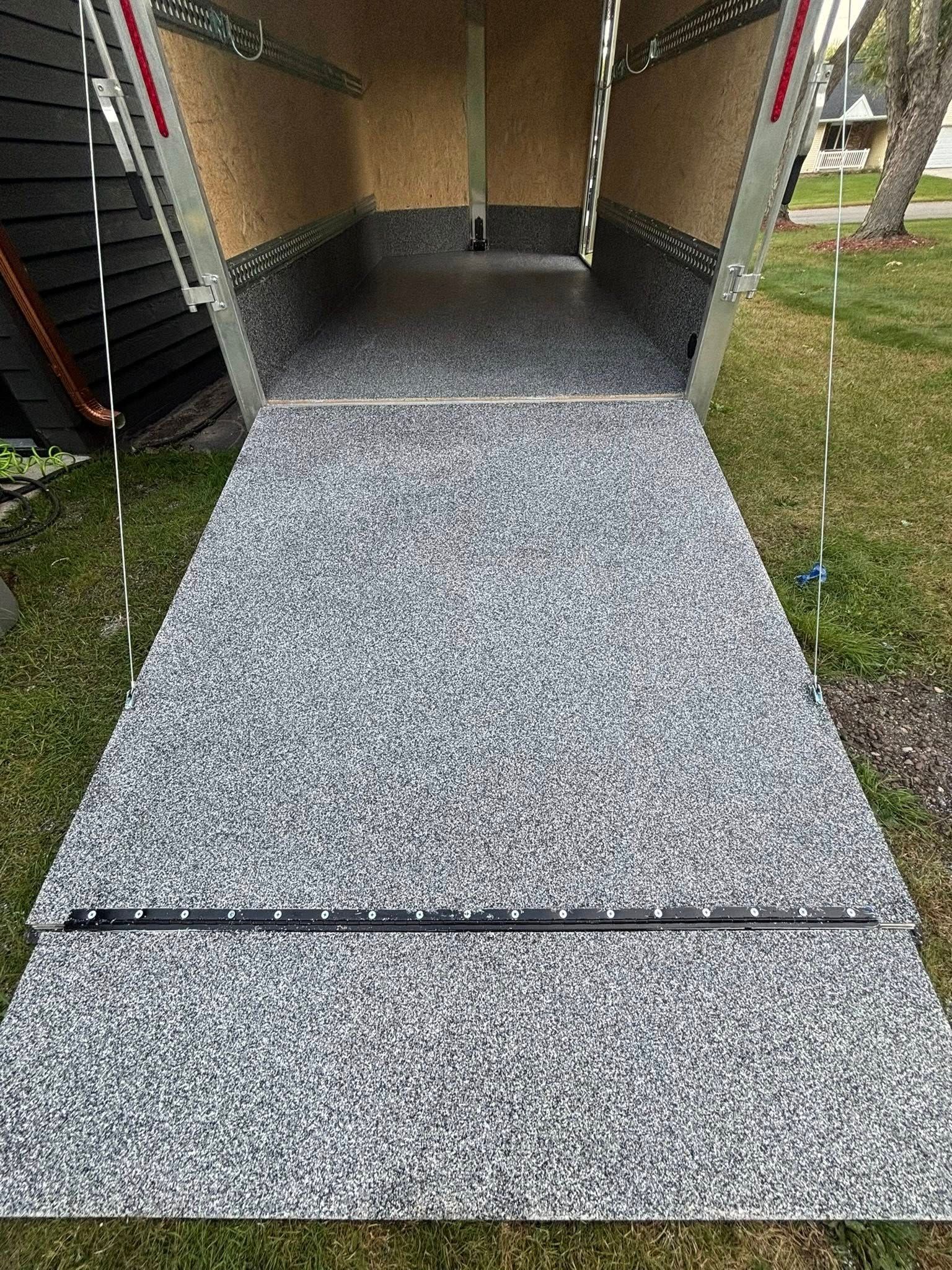 Gravel ramp leading into a small covered entryway beside a staircase and grassy yard