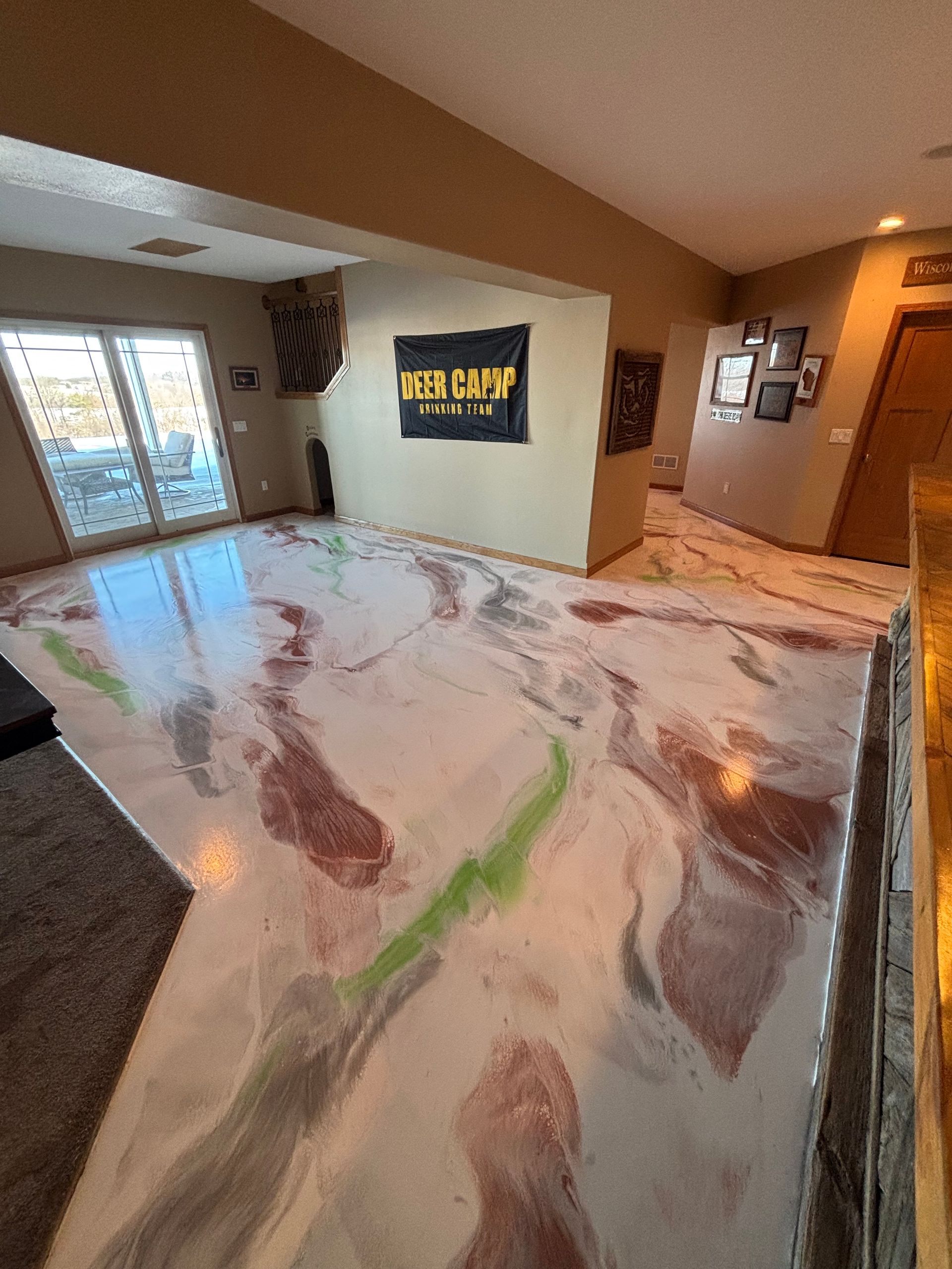 Empty living room with glossy marble-look floor, sliding glass doors, and wall art.