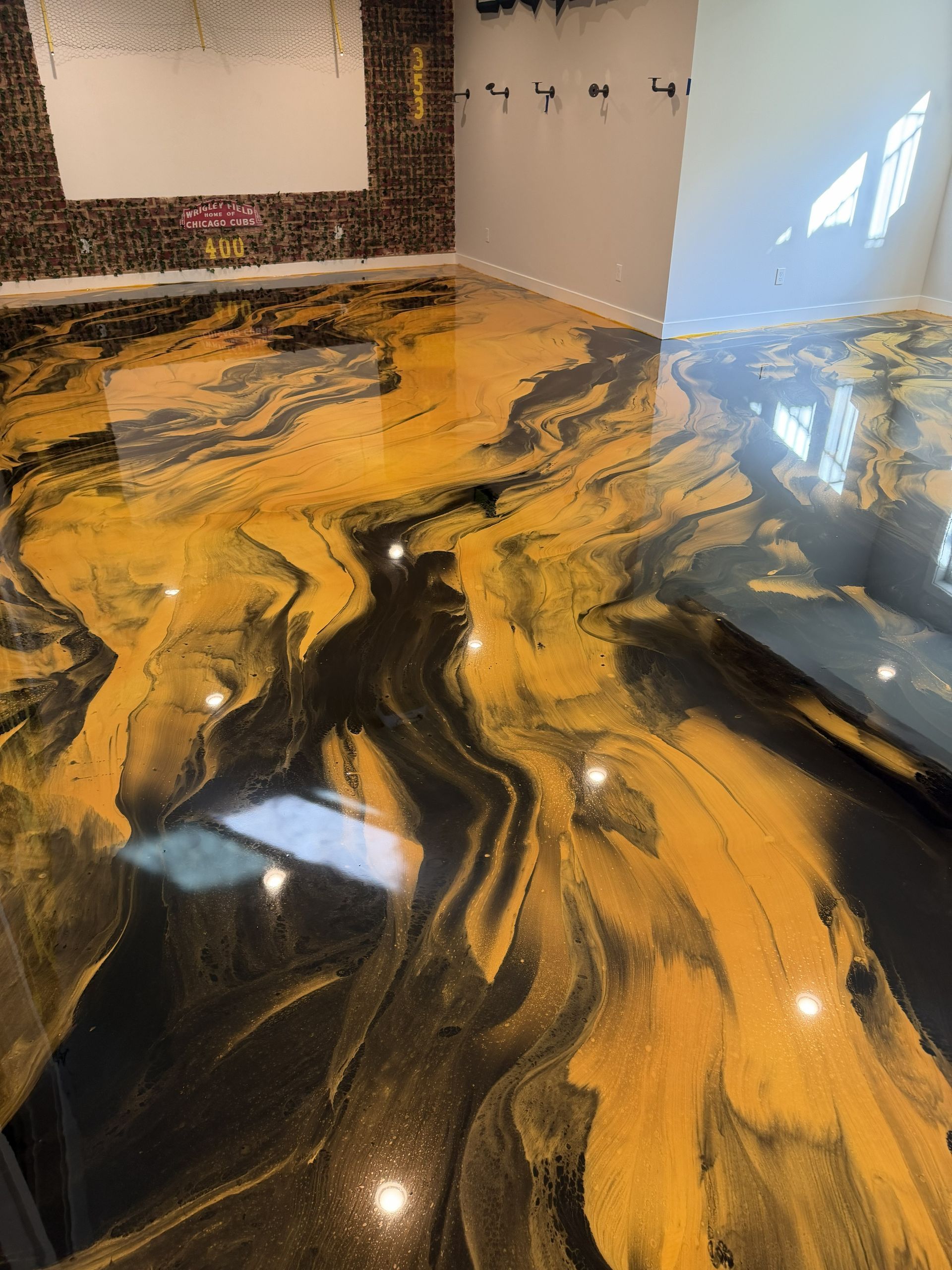Glossy black and amber marbled floor in a modern room with white walls and a bright window reflection