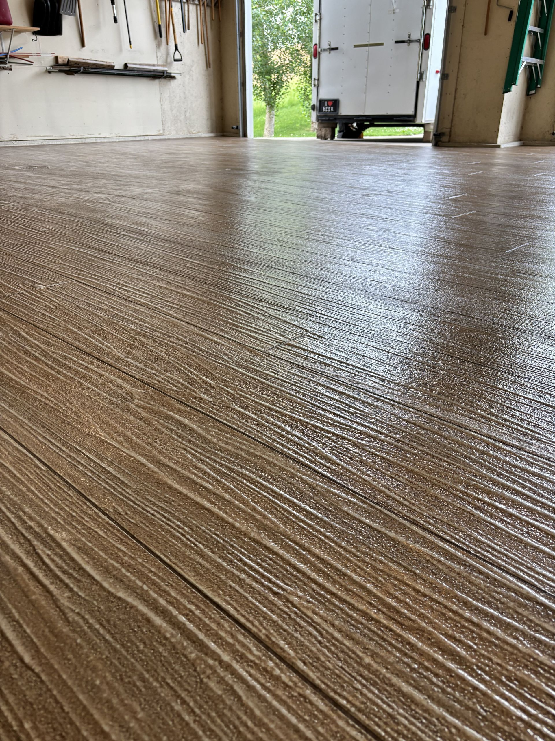 Textured concrete porch floor leading to an open doorway with daylight outside