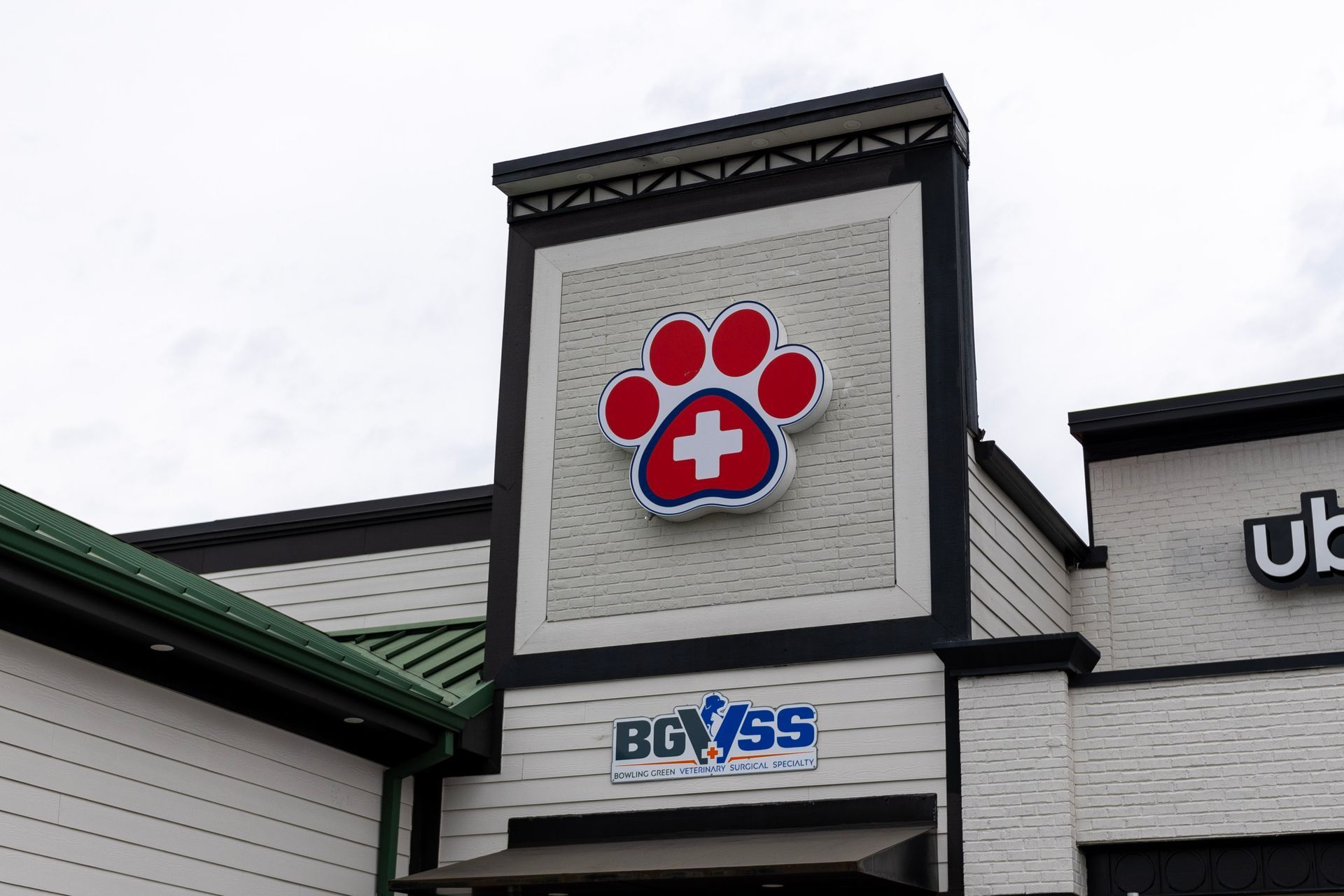 A dog paw with a cross on it is on the side of a building.