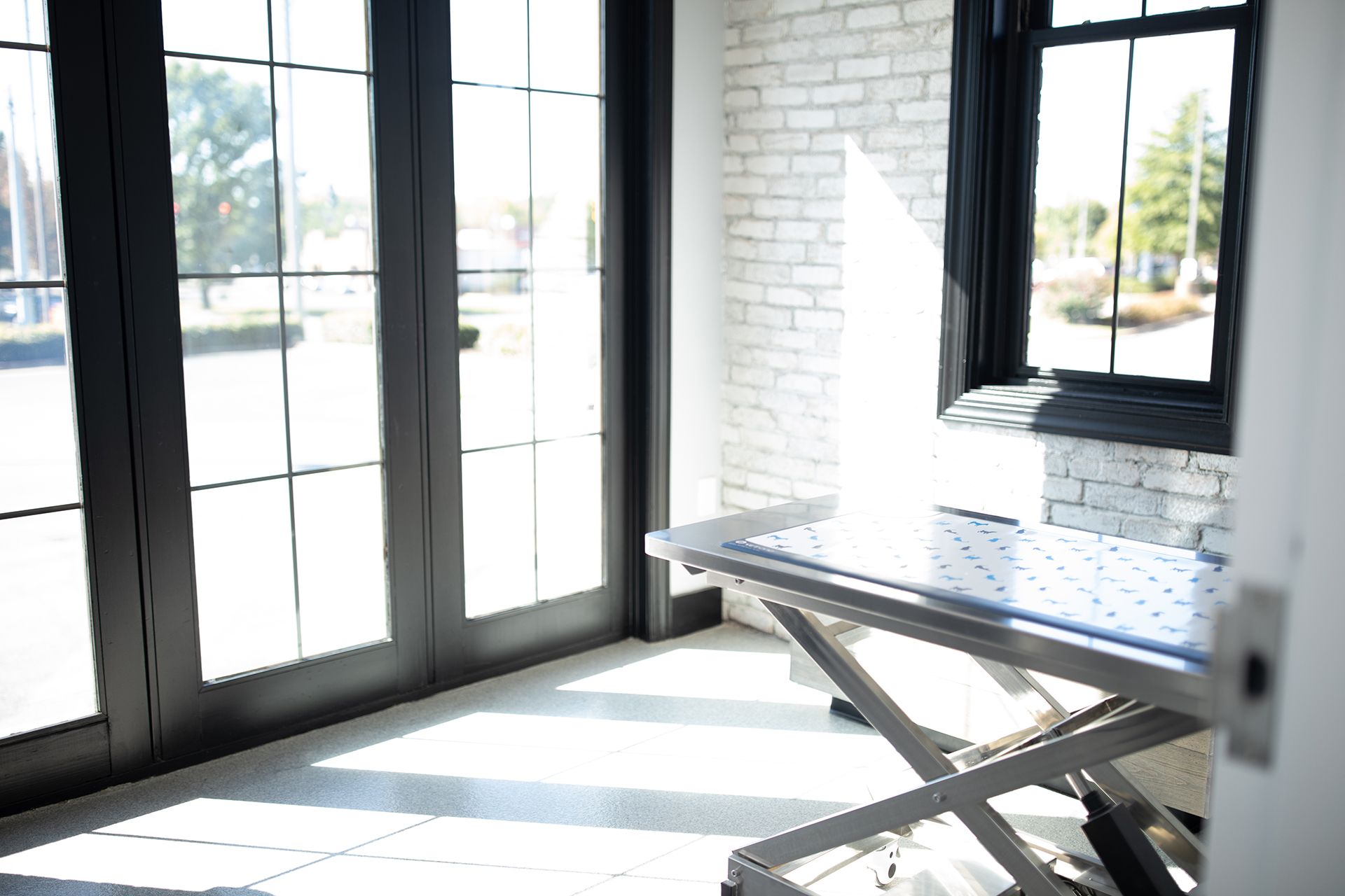There is a table in the middle of a room with a lot of windows.