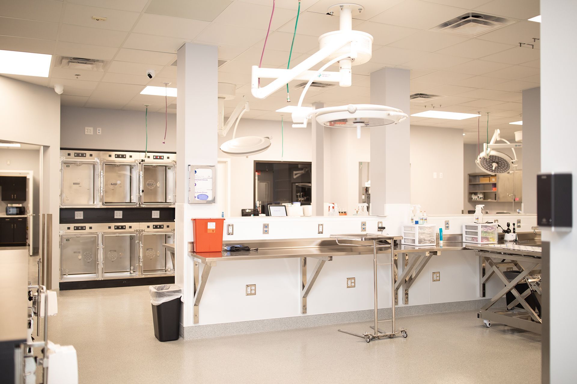 An empty operating room with a stainless steel table and a sink in Bowling Green Veterinary Emergency Clinic.