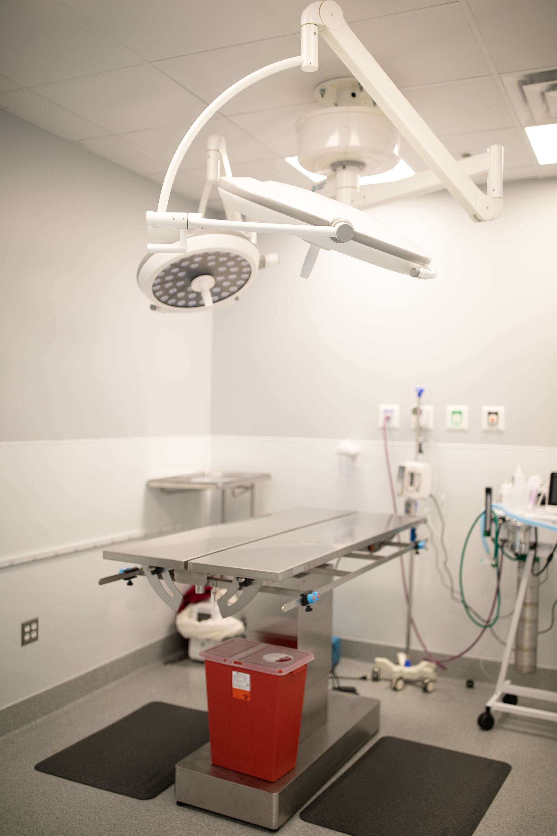 An empty operating room at Bowling Green Veterinary Emergency Clinic with an operating table and a surgical light.