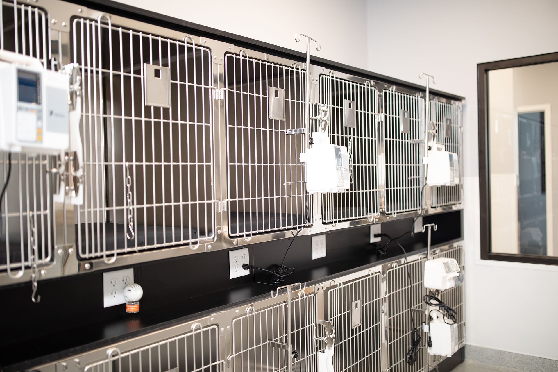 A row of stainless steel cages with infusion pumps in Bowling Green Veterinary Emergency Clinic.