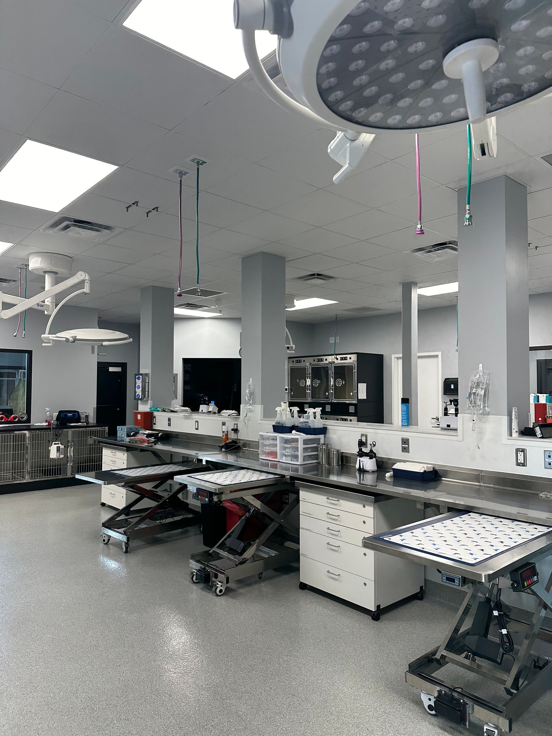 A large operating room at Bowling Green Veterinary Emergency Clinic with tables and a ceiling light.
