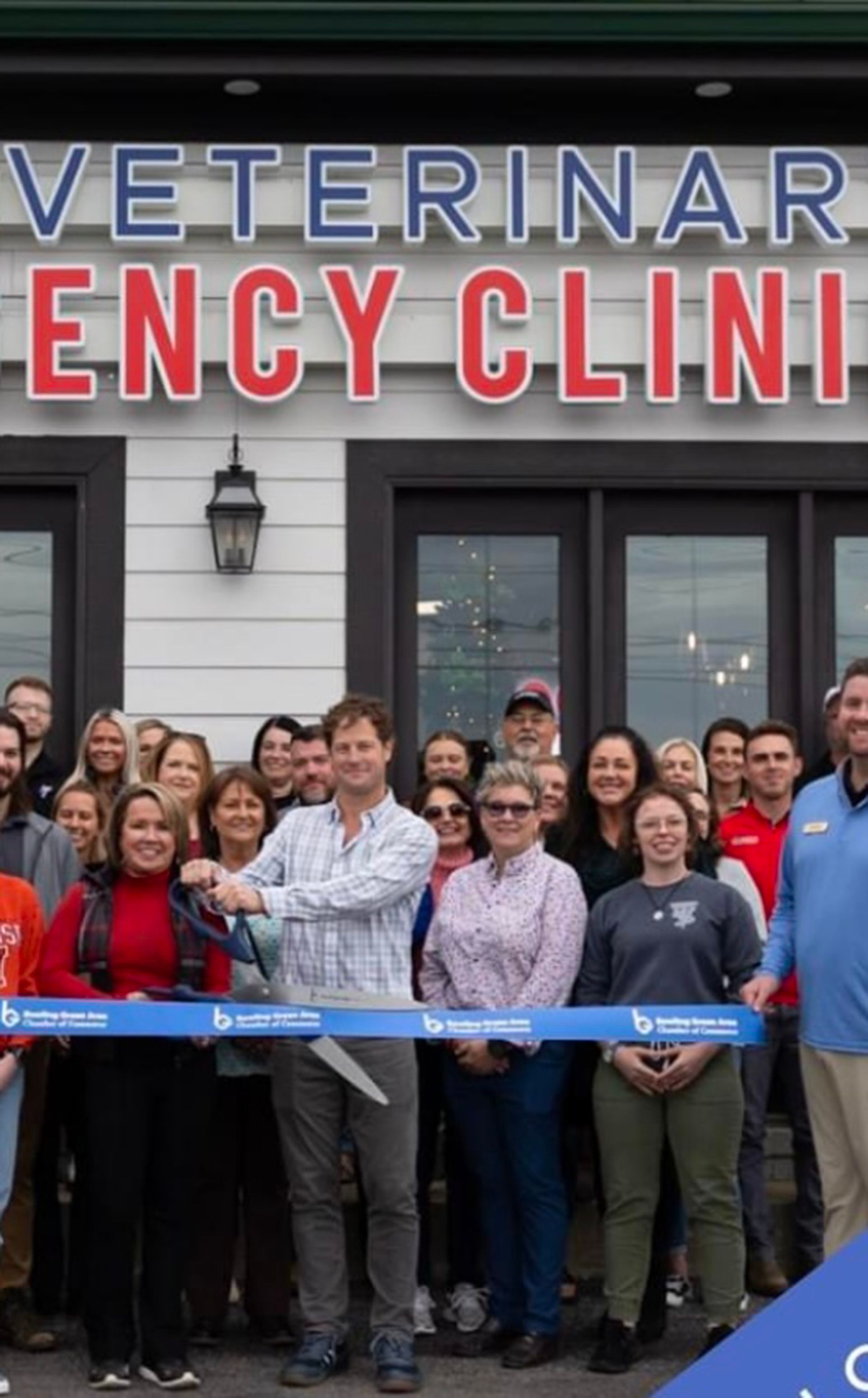 A group of people are standing in front of Bowling Green Veterinary Emergency Clinic.