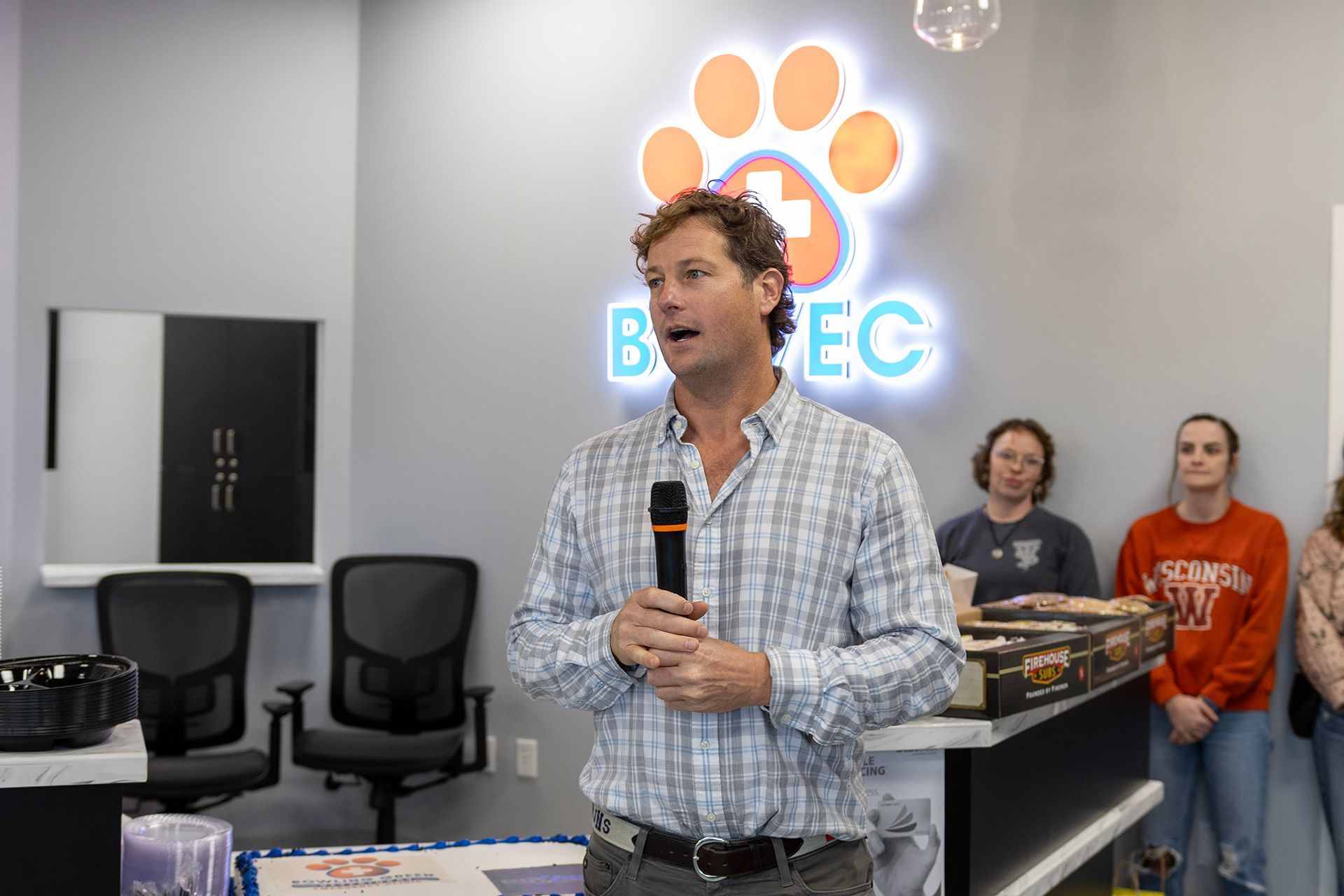 A man is holding a microphone in Bowling Green Veterinary Emergency Clinic.