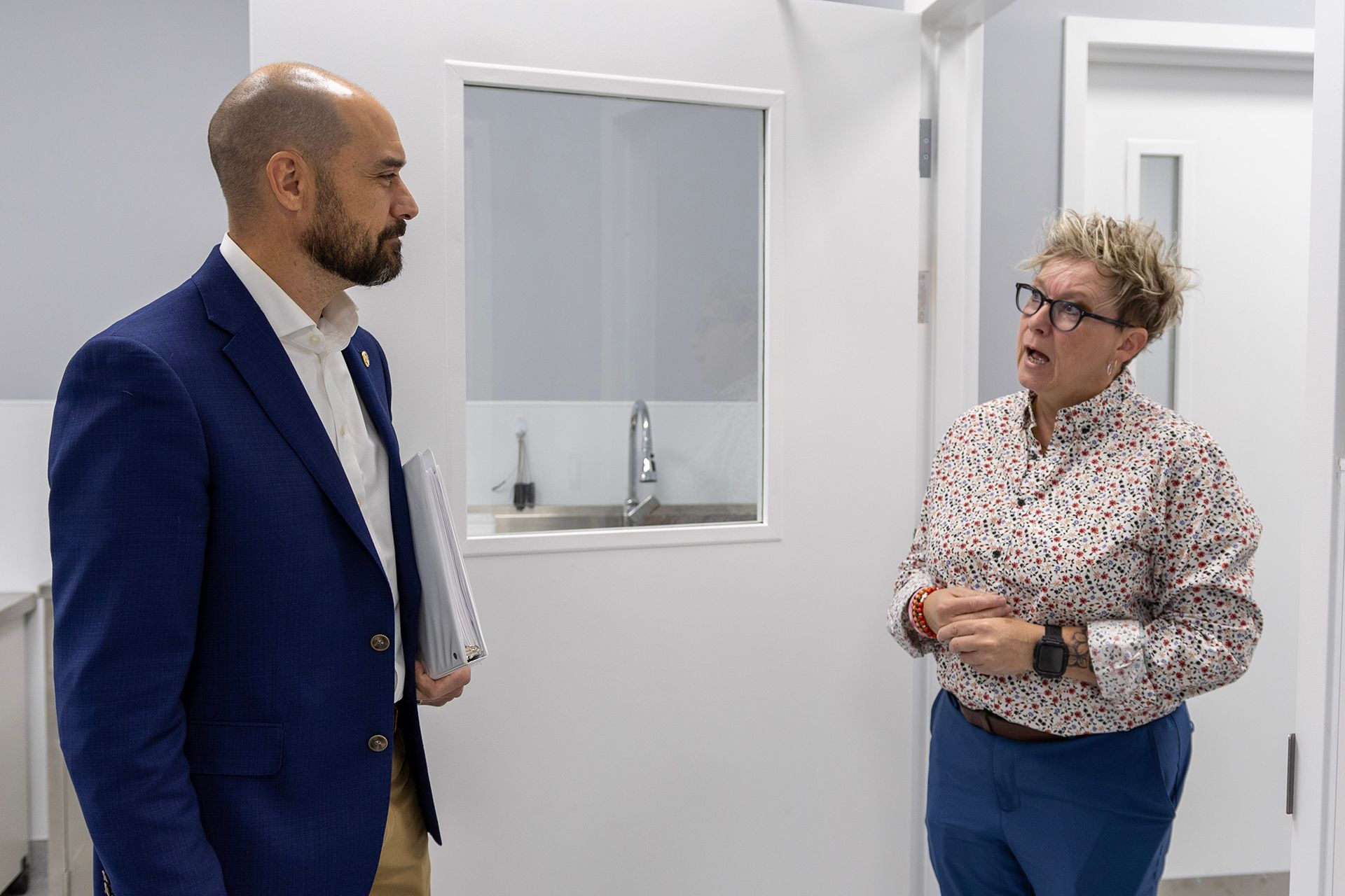 A man and a woman at Bowling Green Veterinary Emergency Clinic are standing next to each other in a room.