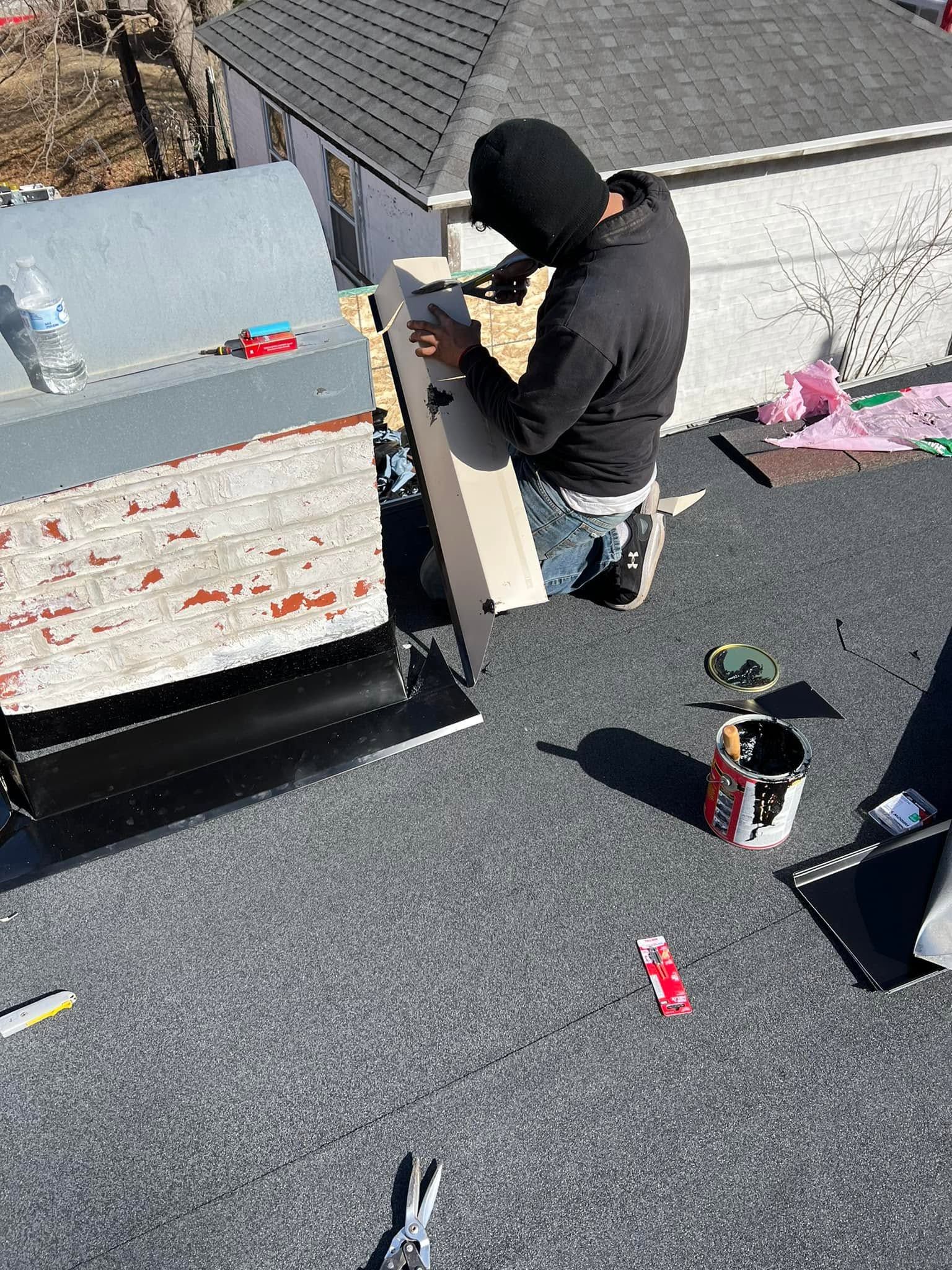 Person in black hoodie works on rooftop beside HVAC unit, with tools and lumber nearby.