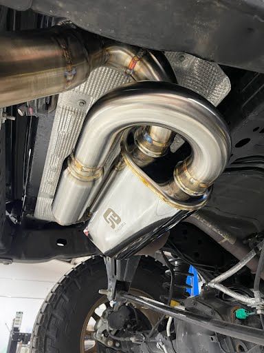 Undercarriage of a vehicle with a stainless steel exhaust system installed.