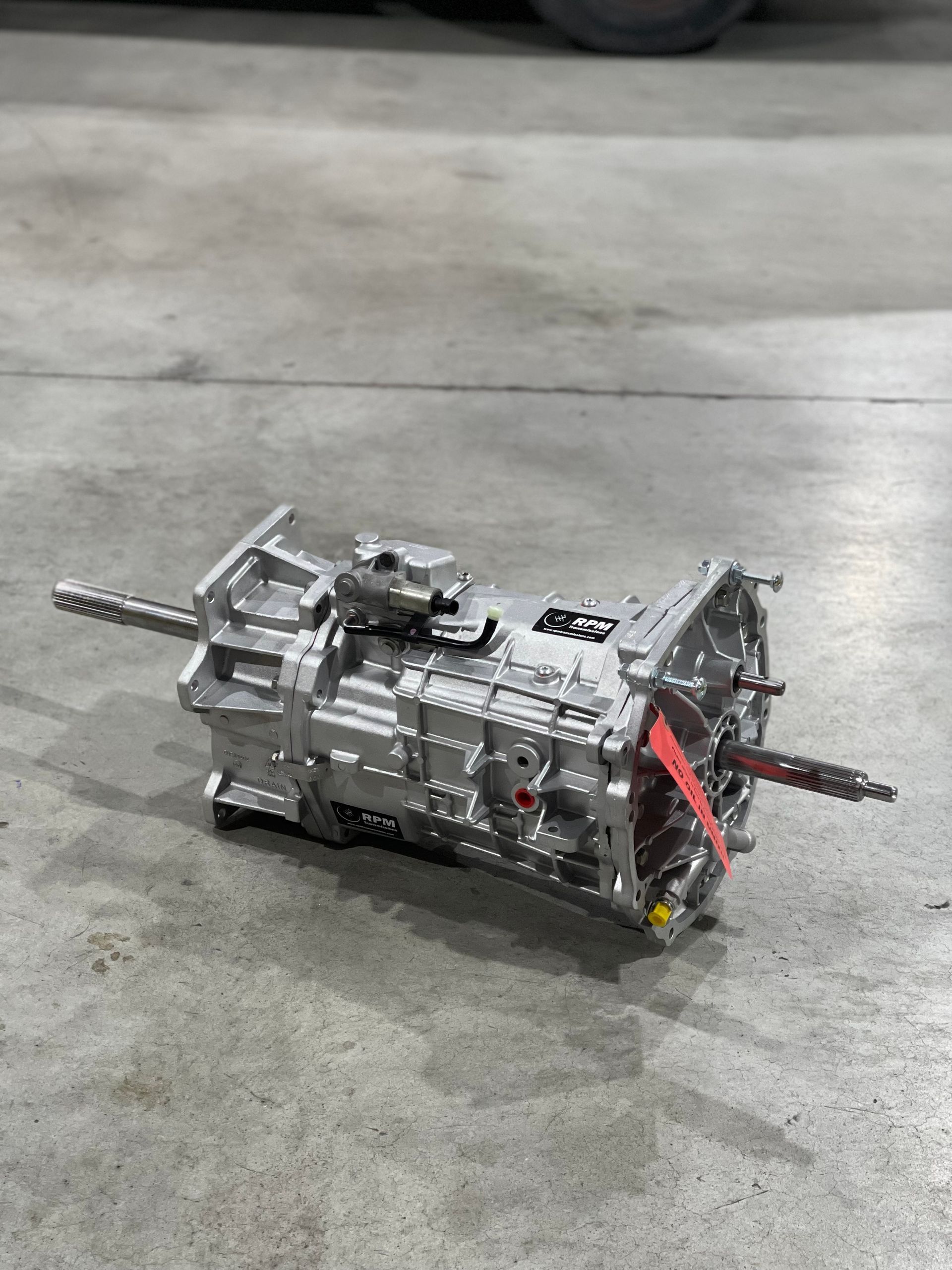 Silver transmission laying on a concrete surface.