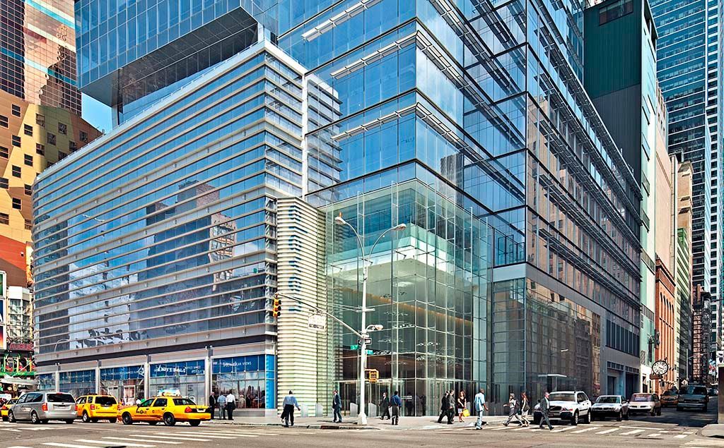 A large building with a lot of windows is in the middle of a city.