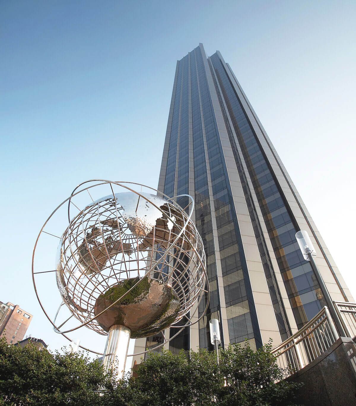 A tall building with a globe in front of it
