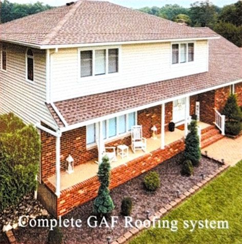 Two-story house with new brown shingle roof and white siding, with porch and landscaping