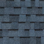 A close-up of dark blue, layered asphalt roofing shingles with a textured, rectangular pattern.