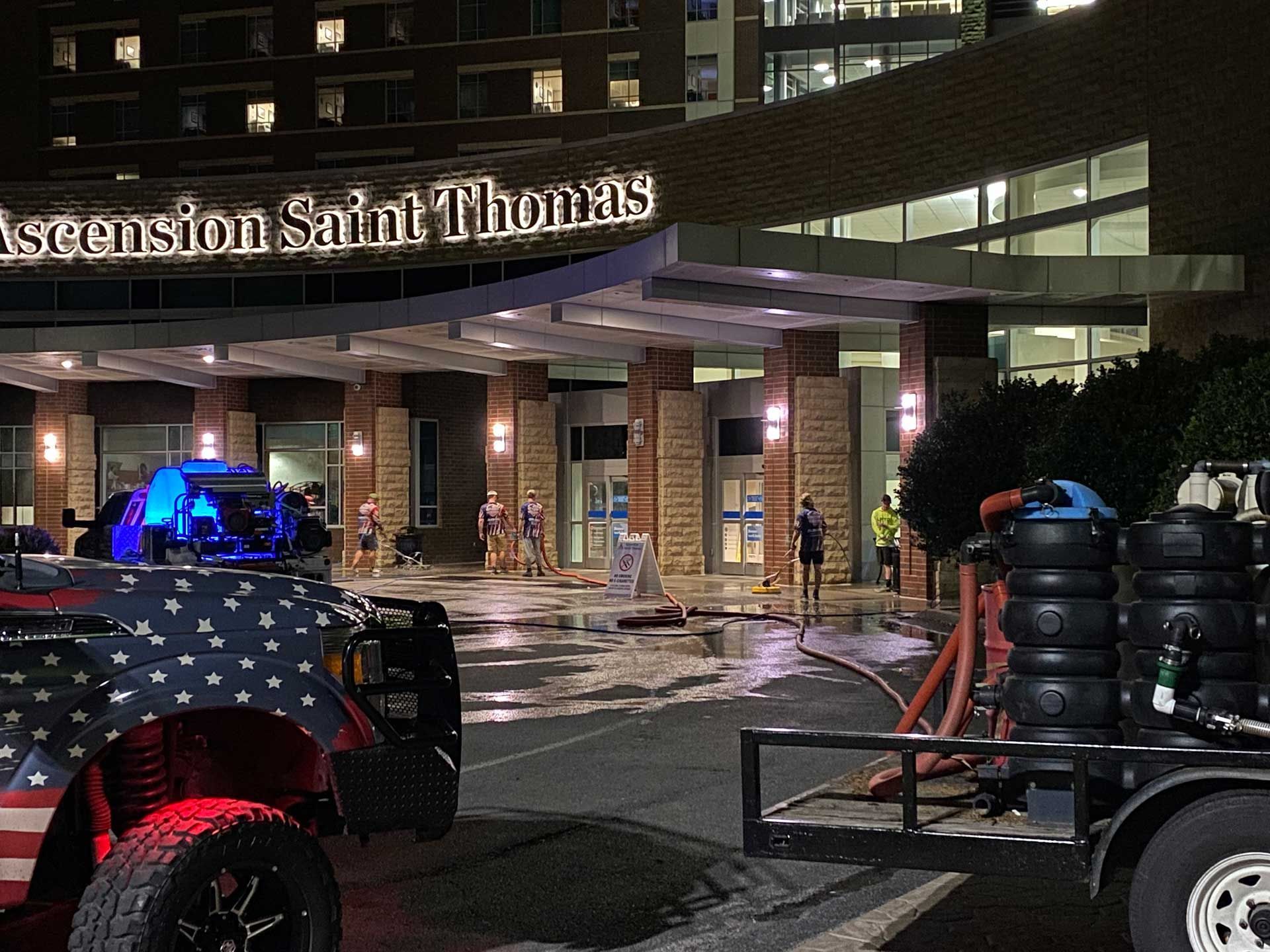 Emergency vehicles outside Ascension Saint Thomas hospital at night.