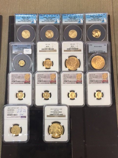 A collection of gold coins in plastic cases