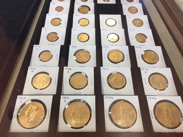 Many gold coins are lined up on a table
