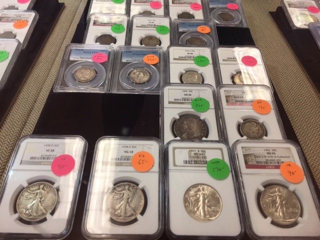 A bunch of coins in plastic cases with neon stickers on them