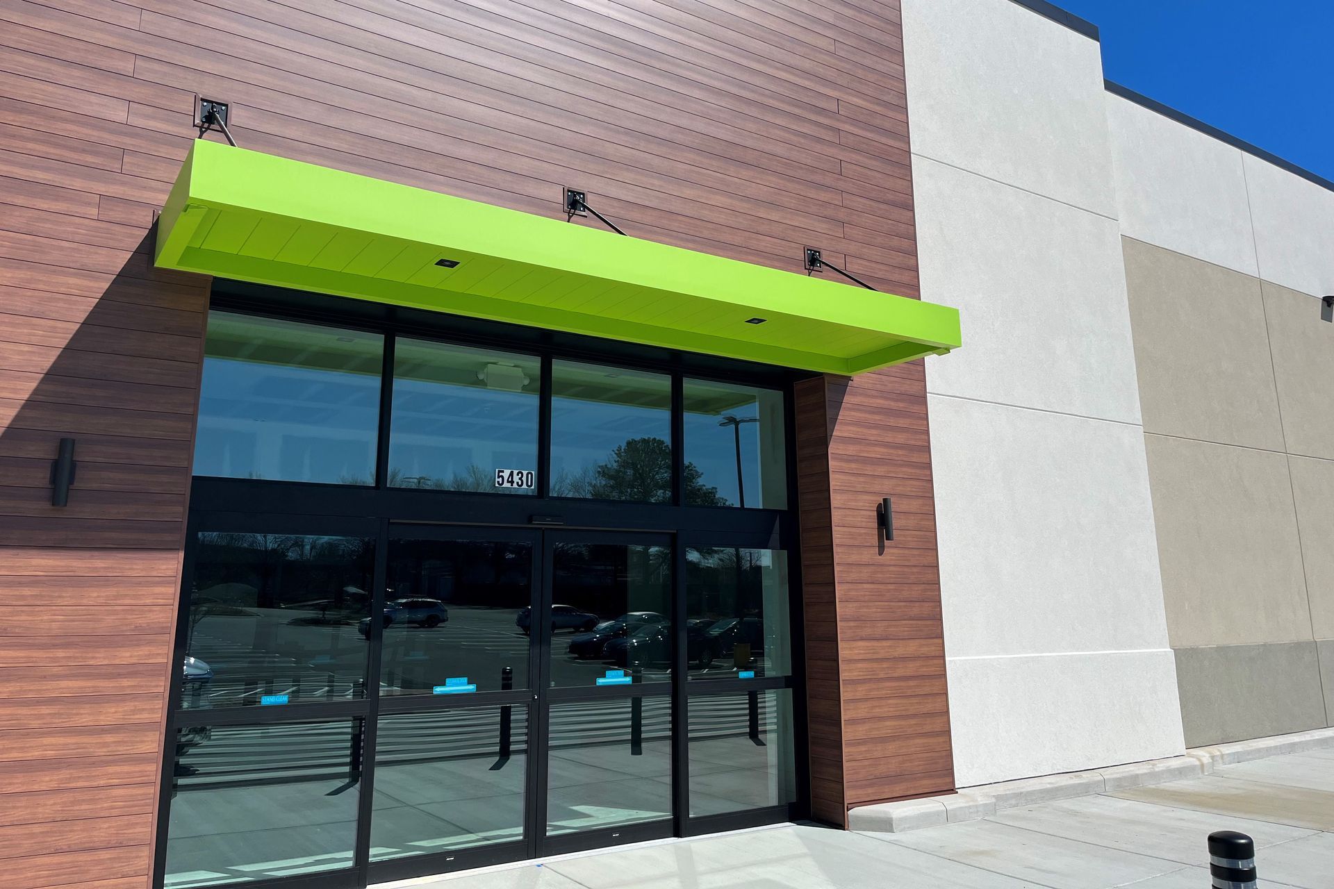 Learn More About Our Powder Coating Services the front of a building with a green awning over the door