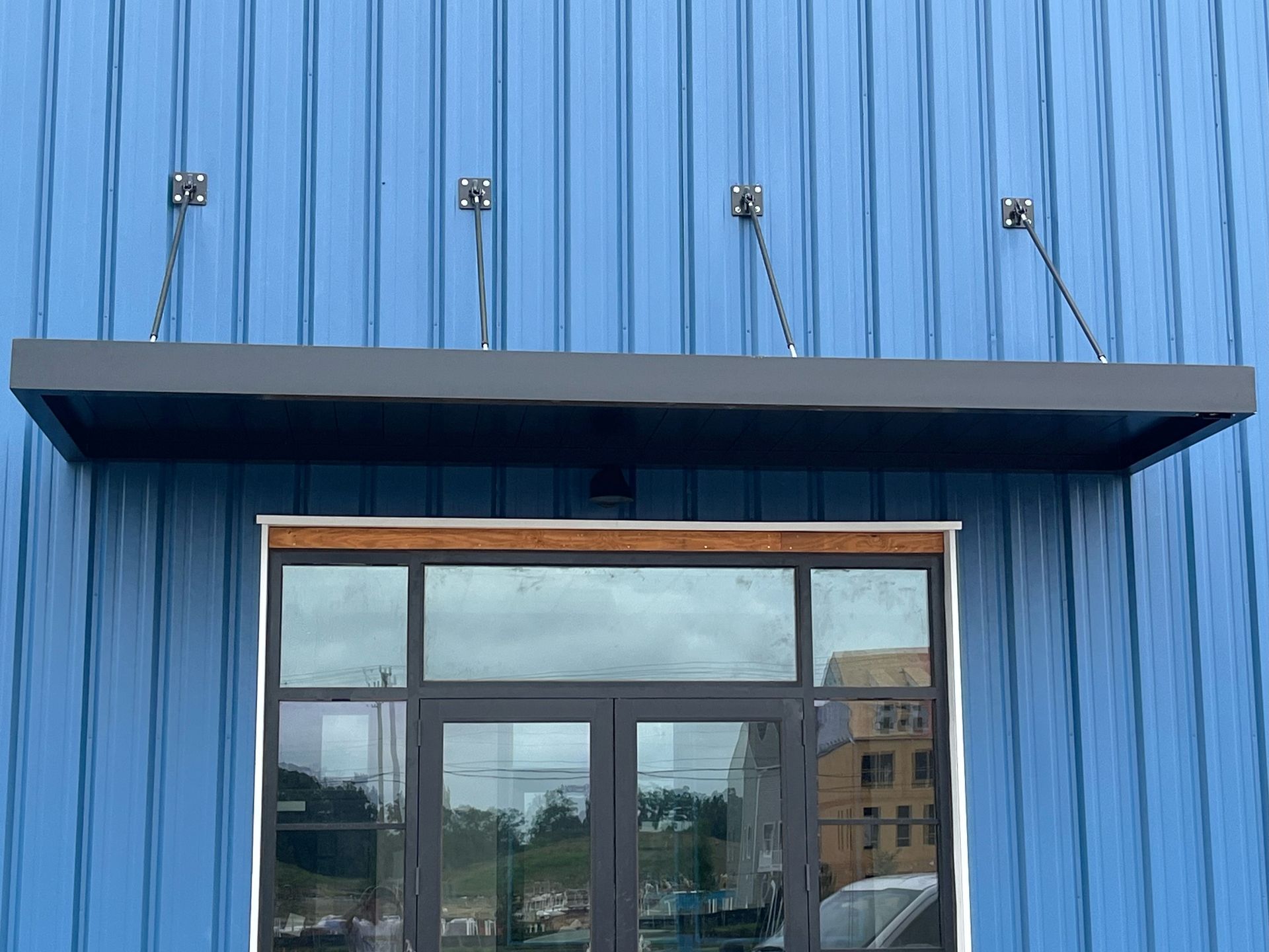 a blue building with a window and a canopy over it