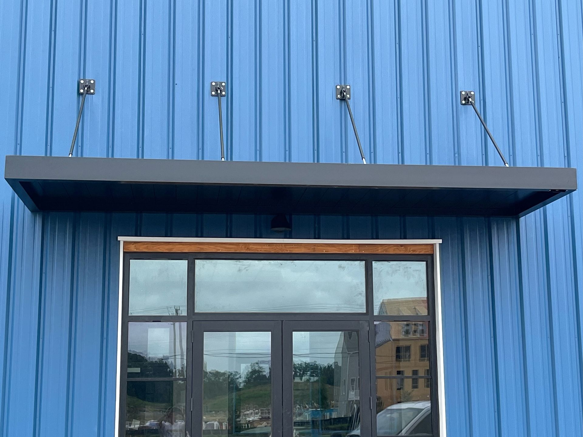a blue building with a window and a canopy over it 