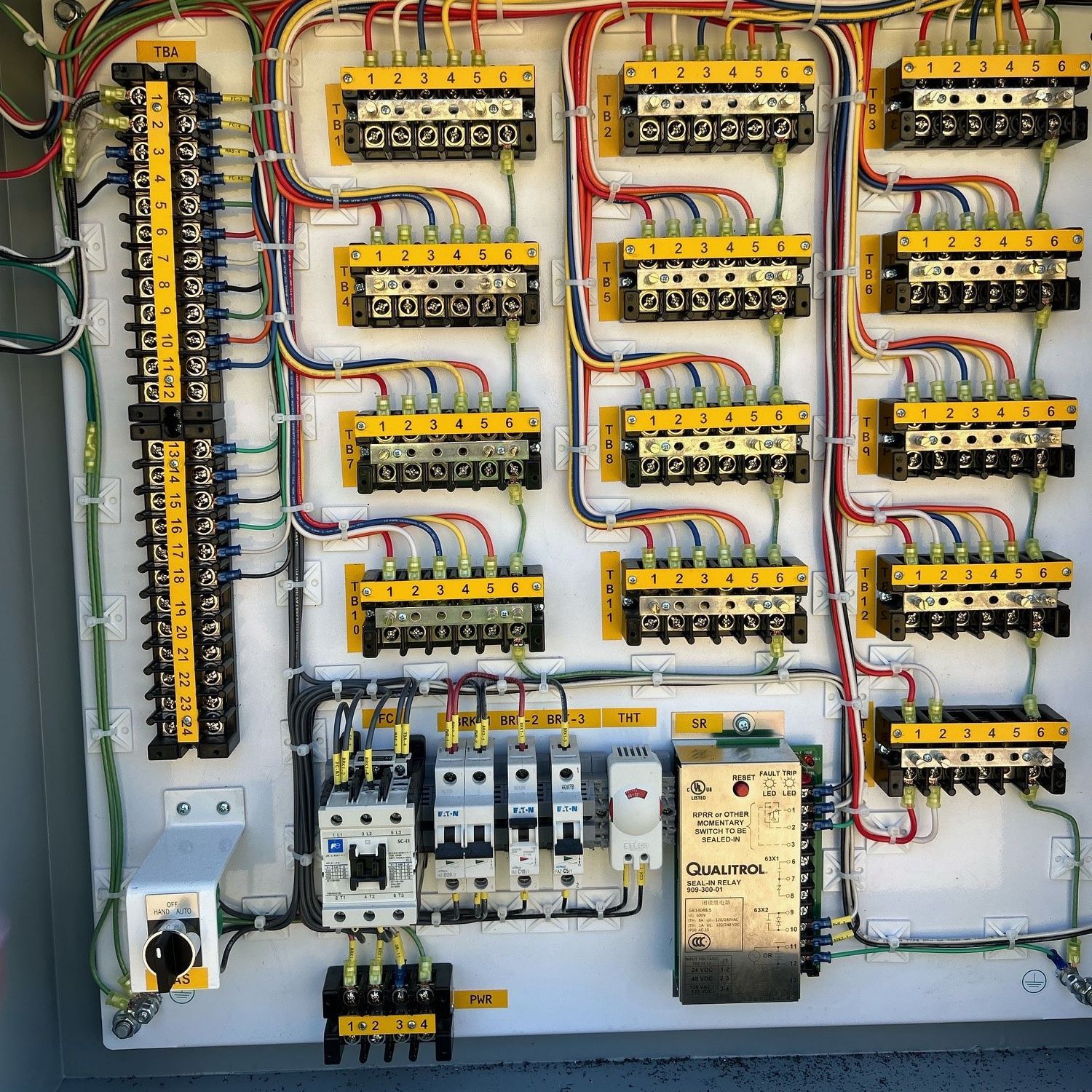 An electrical panel with a lot of wires connected to it