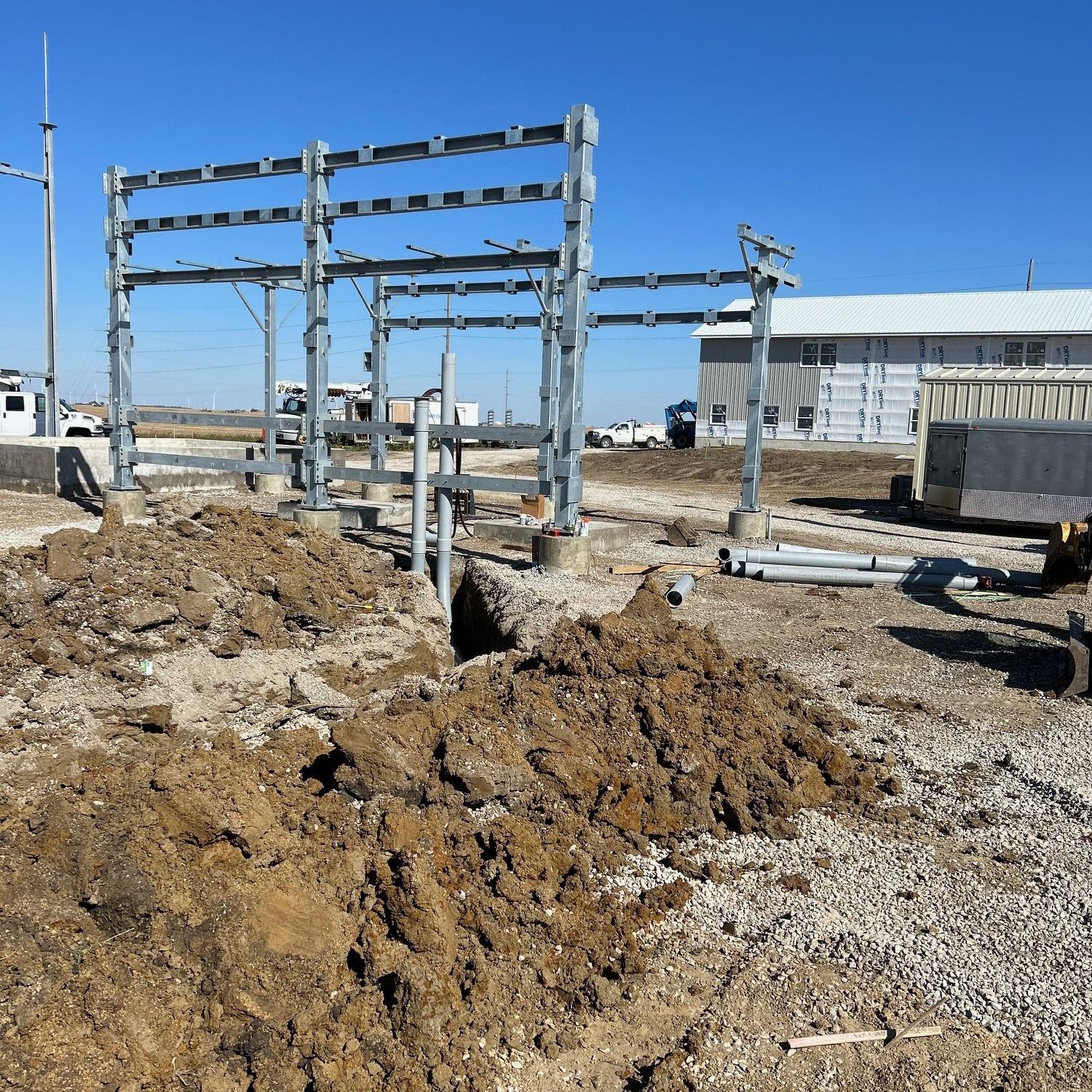 A large pile of dirt is in front of a building under construction