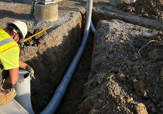 An electrician working on a pipe