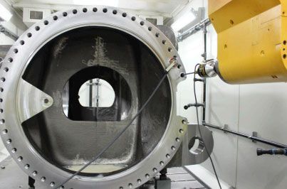 A large metal object is being measured by a machine.