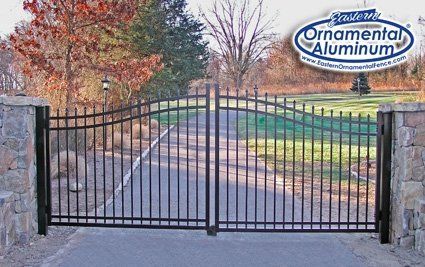 A black aluminum gate with a sign that says ornamental aluminum
