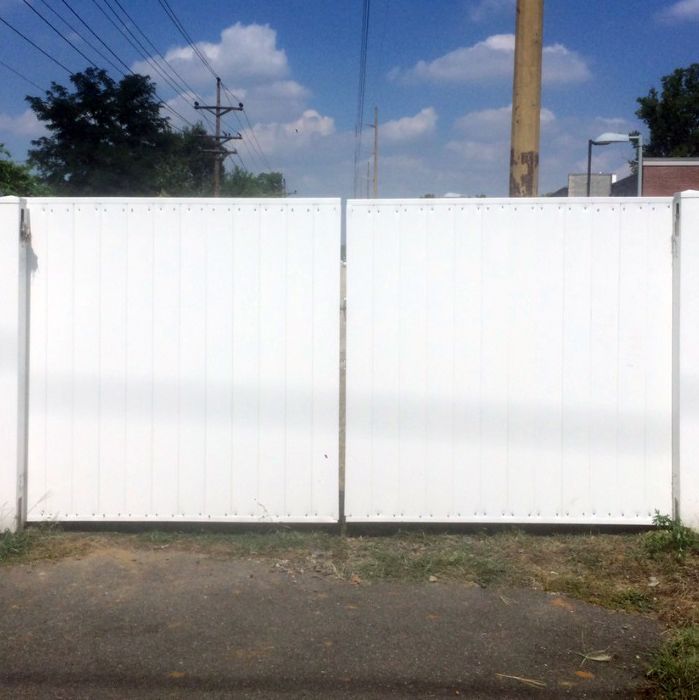 A white fence with a telephone pole in the background