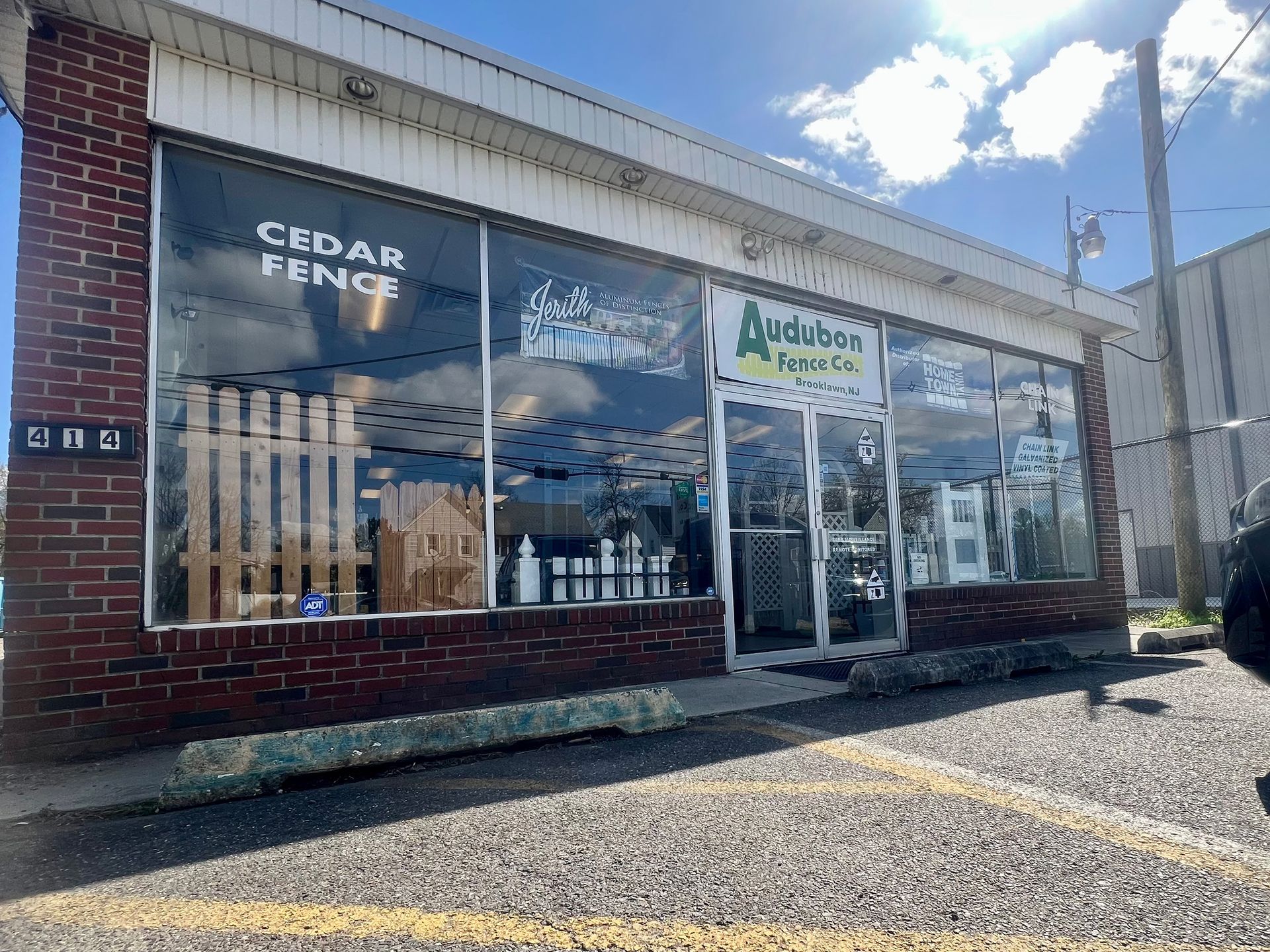 A cedar fence store is located in a brick building with a lot of windows.
