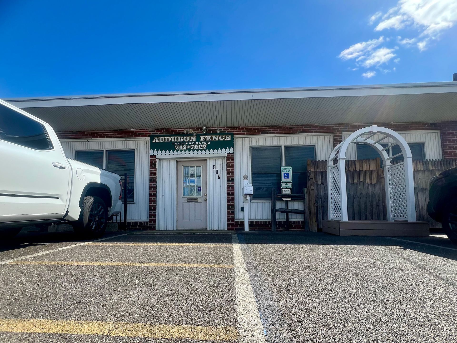 A white truck is parked in front of a building.