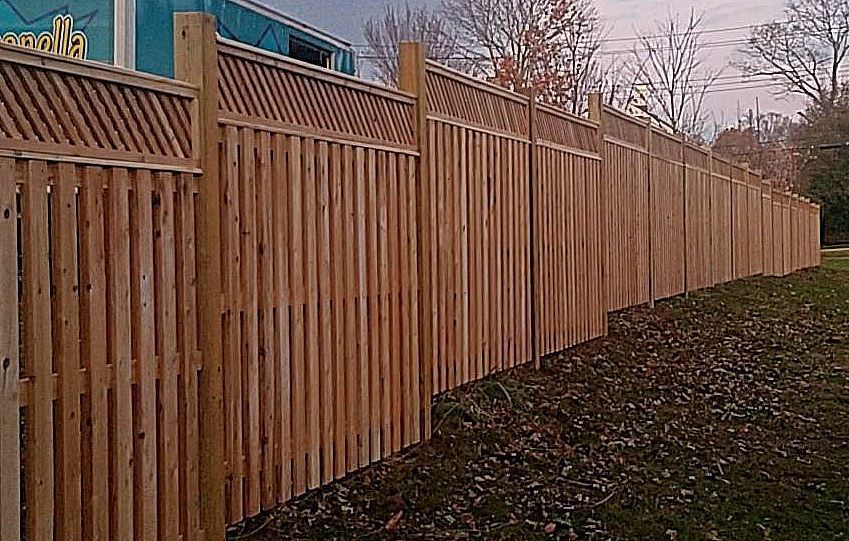 A wooden fence is sitting in the middle of a grassy field.