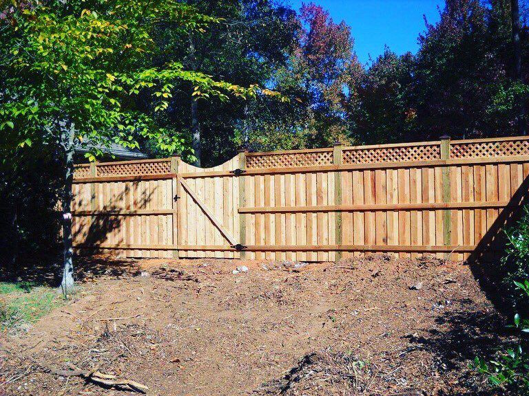 A wooden fence with a gate in the backyard