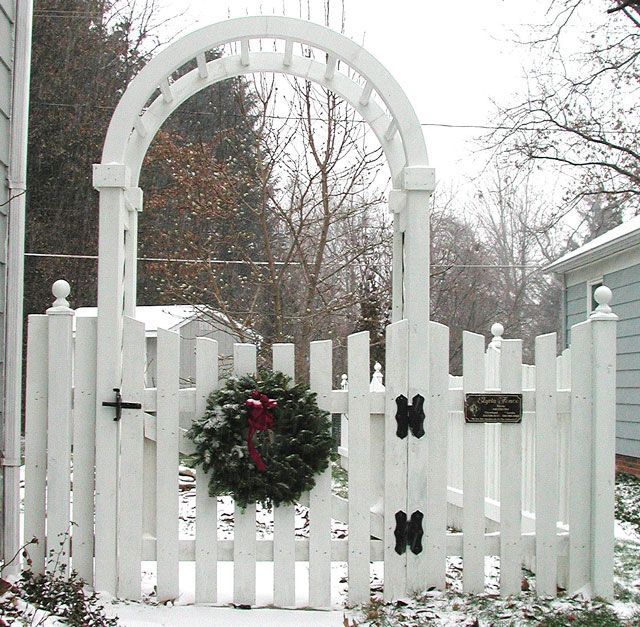 A white fence with a christmas wreath on it