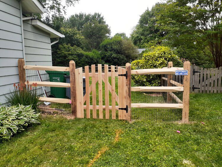 A wooden fence with a gate in front of a house.