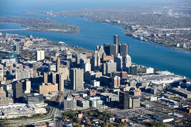 Aerial view of downtown Detroit and the Detroit River under a clear blue sky