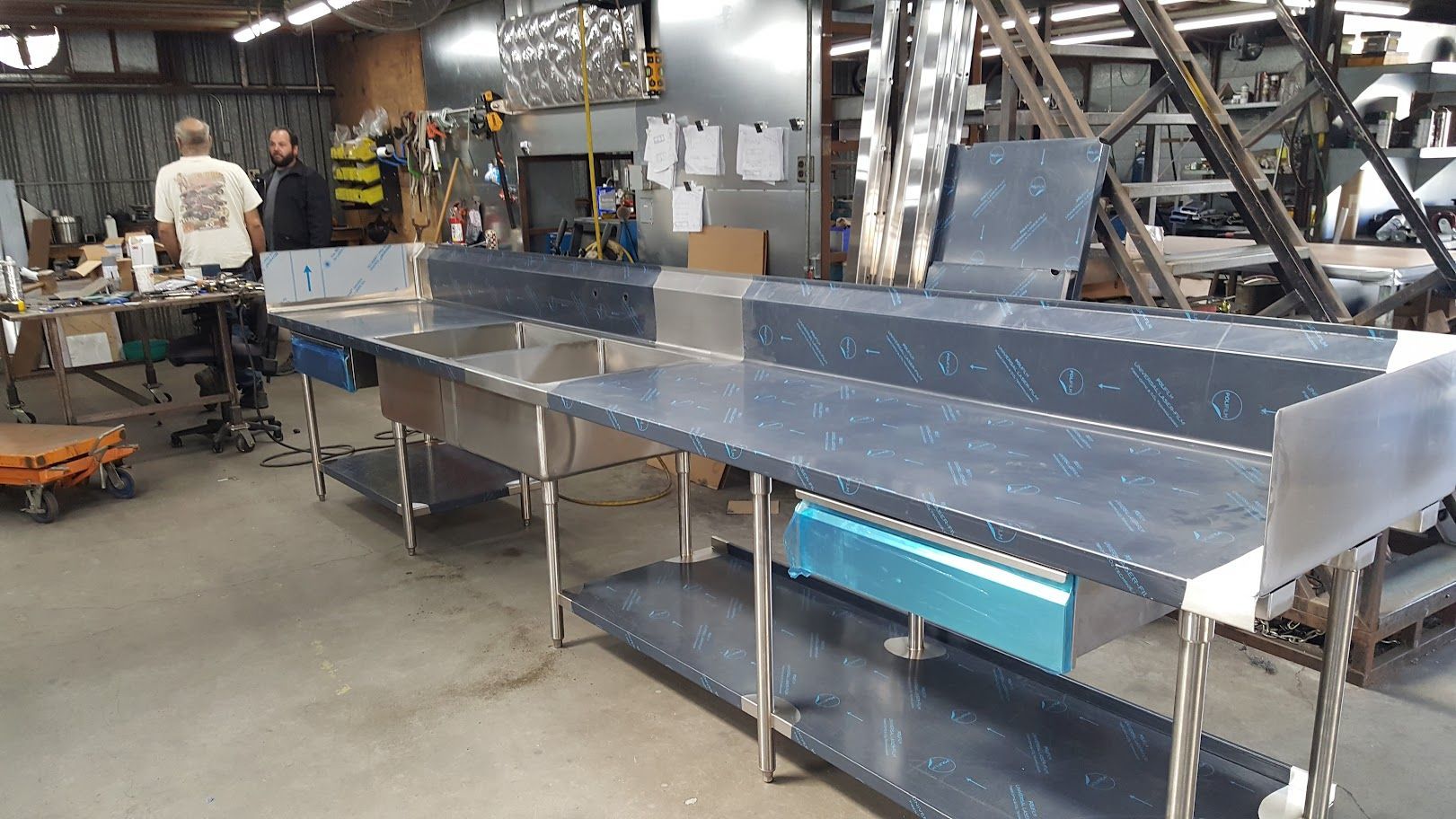 A warehouse filled with lots of stainless steel tables and sinks.