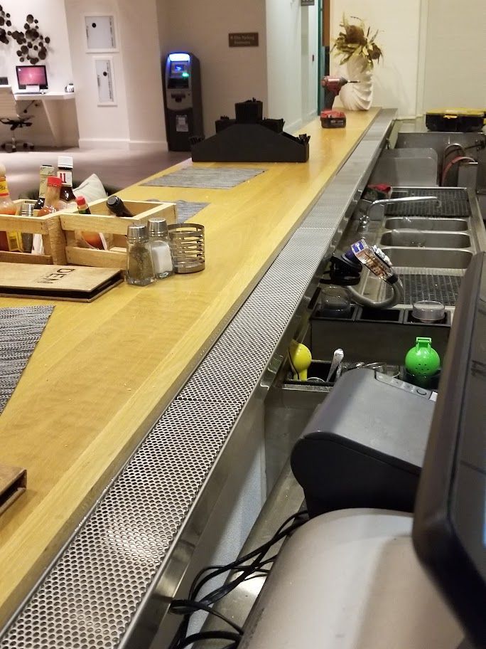 A long counter in a restaurant with a cash register.