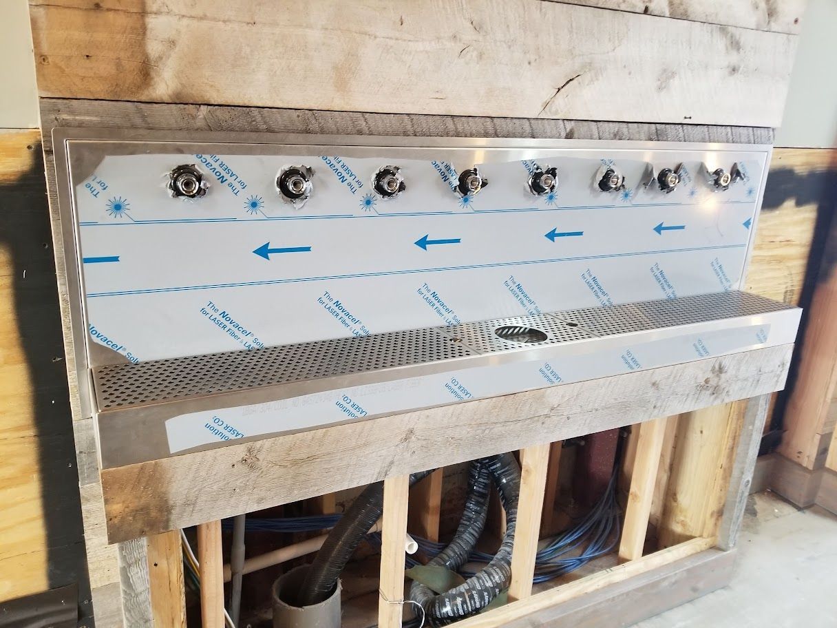 A stainless steel sink is being built in a wooden frame.