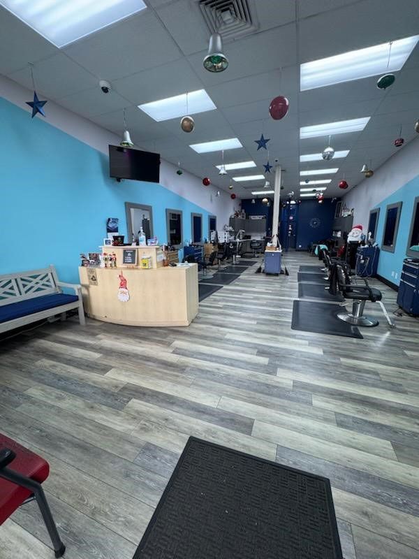 The inside of a salon with a wooden floor and blue walls