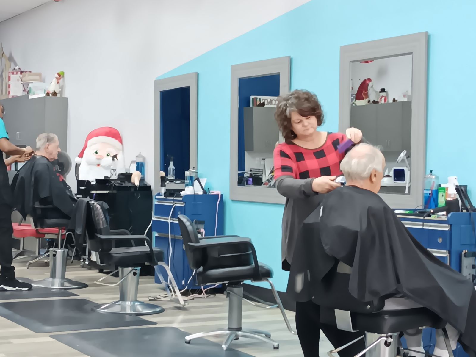 A woman is cutting a clients hair in the salon