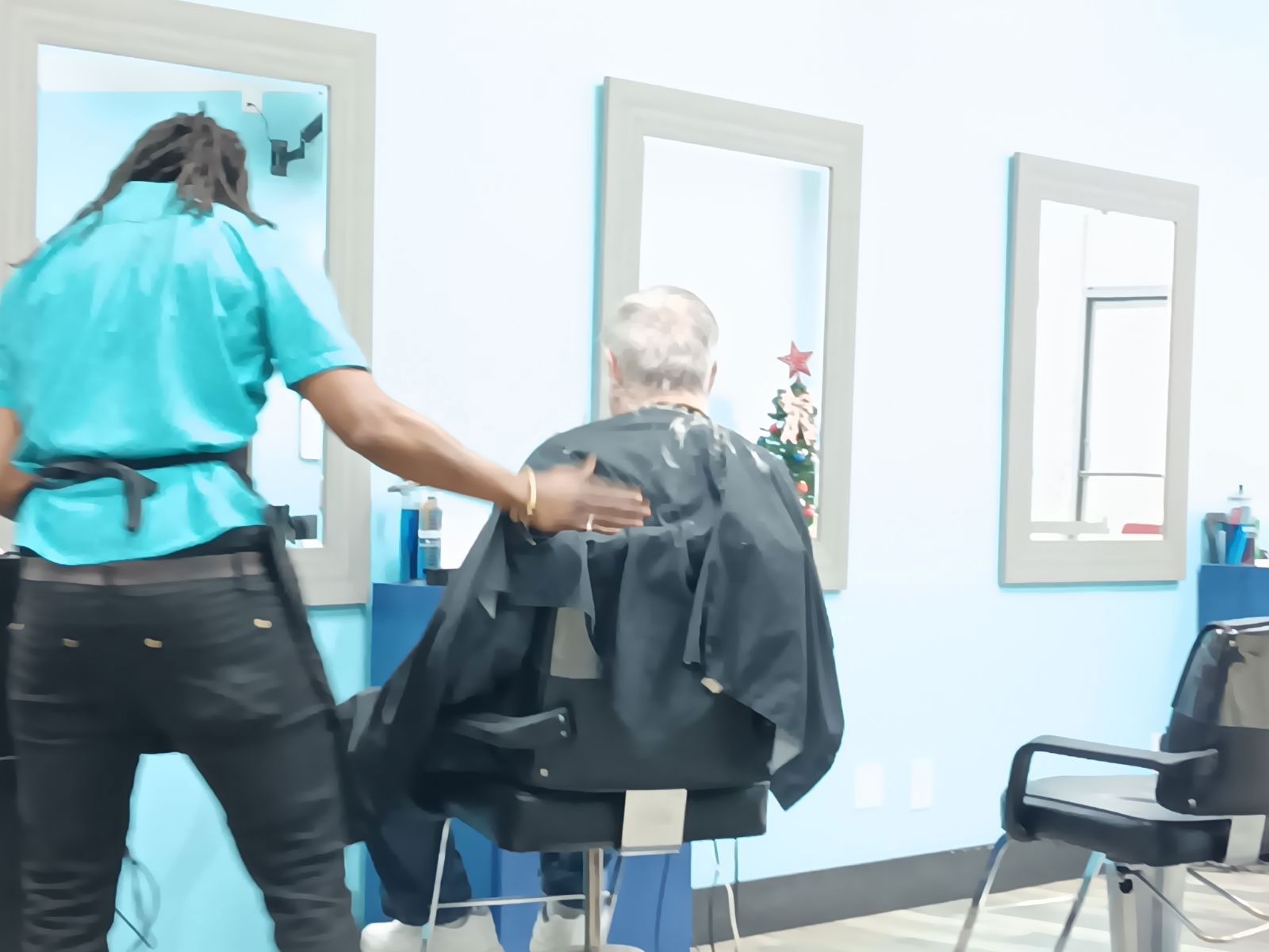 A man is getting his hair cut in a salon