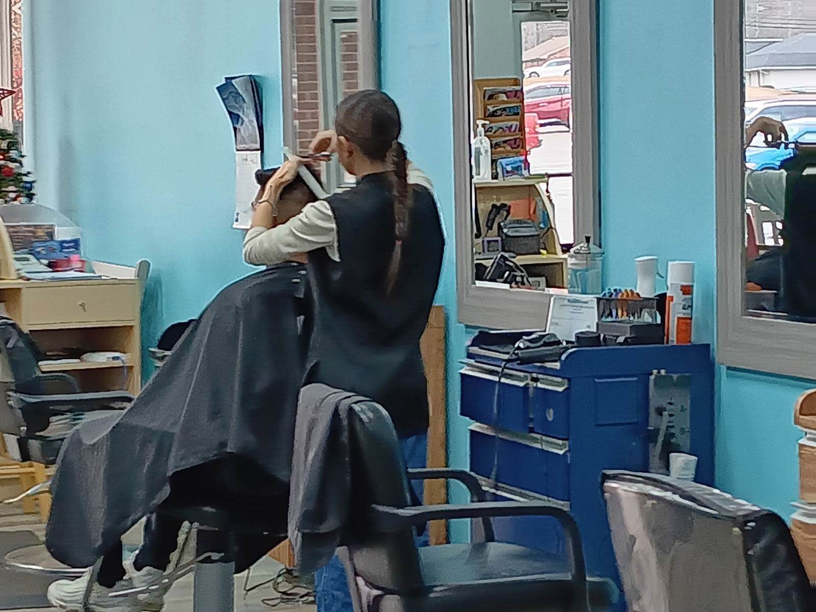 A woman is cutting a customer hair in the hair salon